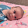 baby, infant, lying_down, blue_clothing, pink_blanket, mermaid_pattern, stars, flowers, face, eyes, skin, cute, child, soft_lighting, indoors, young, portrait, head, resting, calm