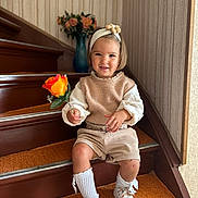 Zoé participe au concours pour gagner de l'argent avec cette photo : beige_clothing, carpet, child, cute, decor, flower, happy, headband, home_interior, indoor, knee_socks, person, portrait, rose, smiling, stairs, toddler, vase, white_shoes, young_child