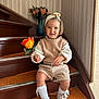 beige_clothing, carpet, child, cute, decor, flower, happy, headband, home_interior, indoor, knee_socks, person, portrait, rose, smiling, stairs, toddler, vase, white_shoes, young_child