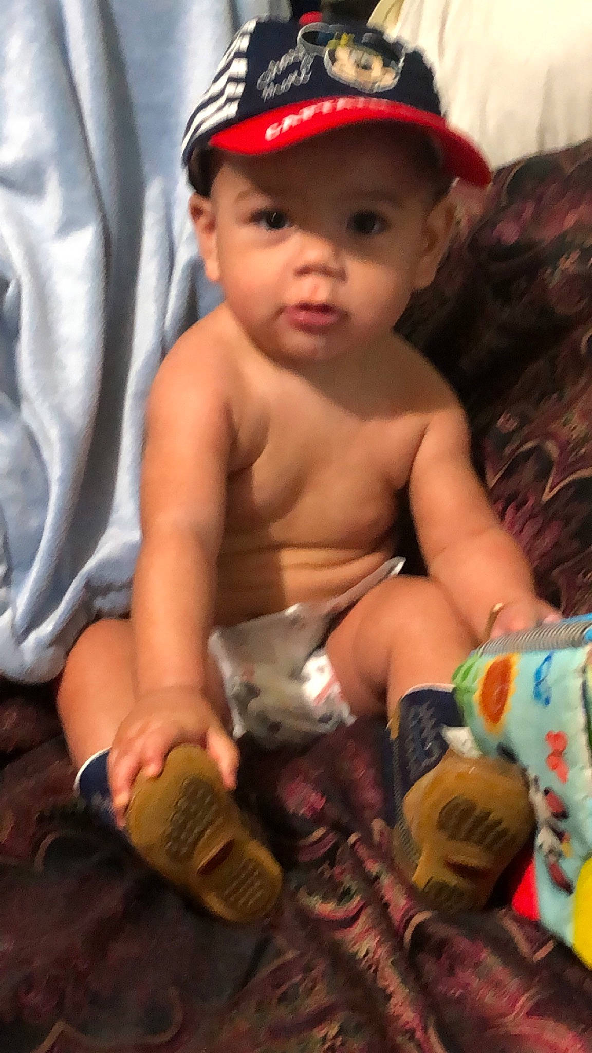 Adriel is registered to the contest to win money with this photo: arm, baby, cheek, child, headwear, person, sitting, skin, toddler