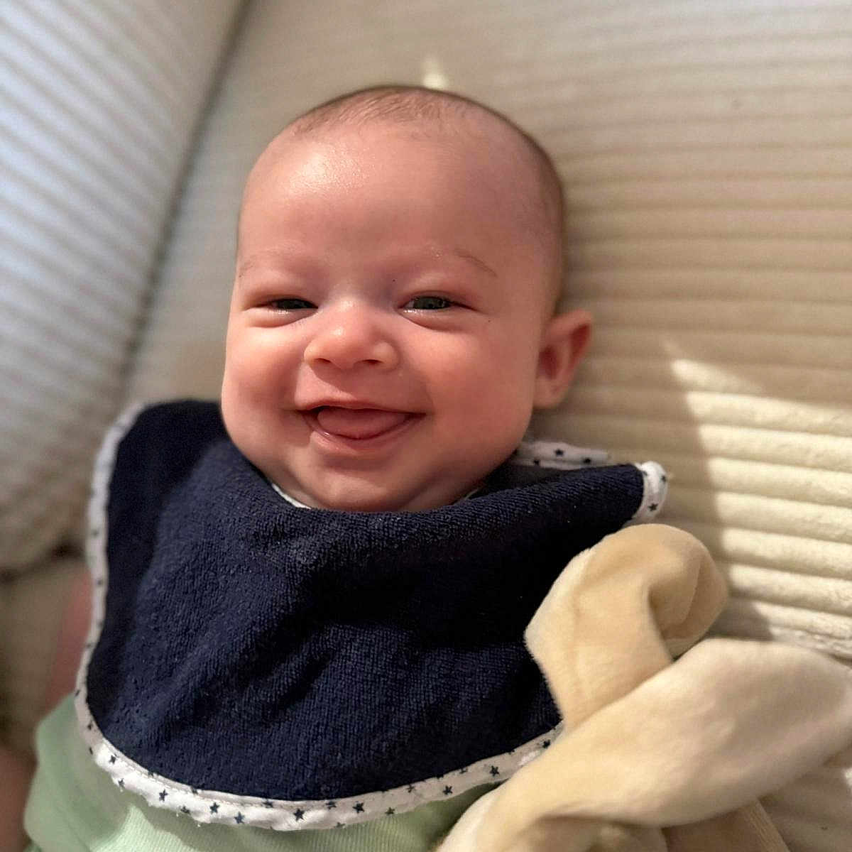 Timéo a rejoint le concours — aidez-le/la à gagner de superbes lots ! baby, baby_bib, bib, bunny_ears, child, closeup, clothing, cozy, cute, face, happy, head, indoor, infant, lying_down, plush_toy, portrait, skin, smiling, soft_toys