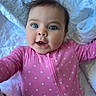 Haddie is registered to the contest to win money with this photo: baby, infant, child, pink_onesie, polka_dots, blue_eyes, quilt, blanket, soft_texture, lying_down, curious_expression, hair_tuft, indoor, cute, smiling, portrait, closeup, person, young_child, sleepwear