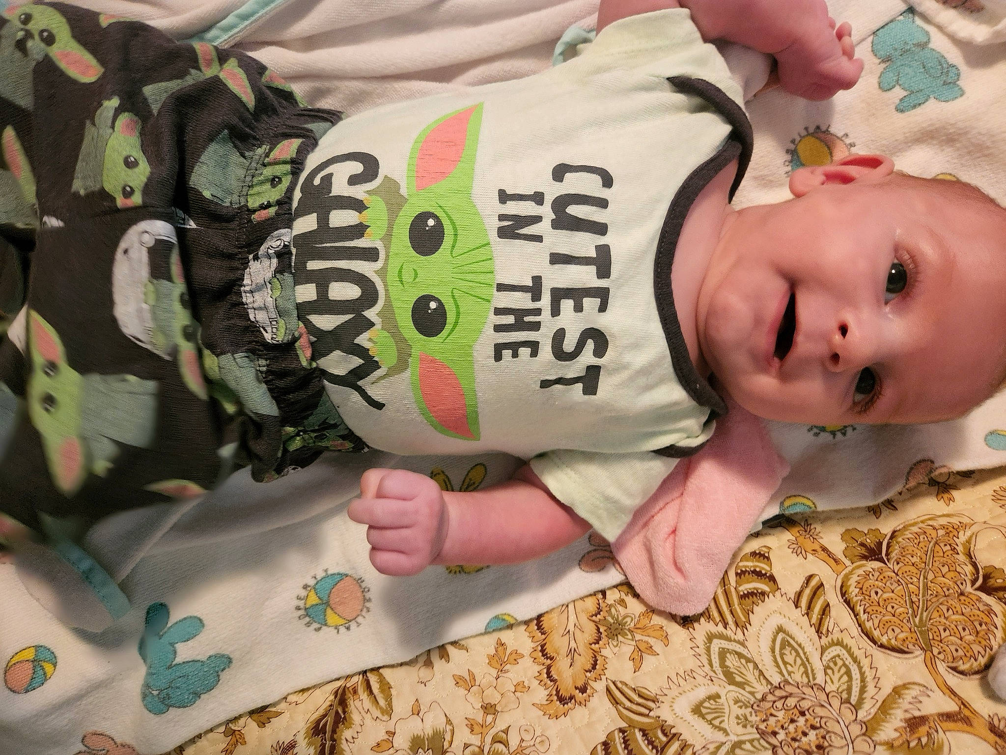 Jane is registered to the contest to win money with this photo: baby, baby_products, baby_toddler_clothing, cheek, child, eyelash, food, grass, green, hand, happy, hat, pattern, person, personal_protective_equipment, sitting, sleeve, textile, toddler, white