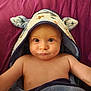 baby, child, hooded_towel, blue_eyes, blanket, cute, infant, face, portrait, skin, expression, towel, ears, soft_texture, lying_down, indoor, young_child, curious, closeup, adorable