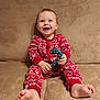 baby, beige, candy_cane, child, couch, cozy, cute, face, feet, happy, holiday, indoors, infant, pajamas, portrait, red_clothing, sitting, smiling, toy, young_child