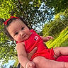 baby, child, outdoor, greenery, trees, sunlight, red_clothing, pigtails, bows, cute, infant, person, hand, grass, nature, daylight, portrait, happy, skin, summer