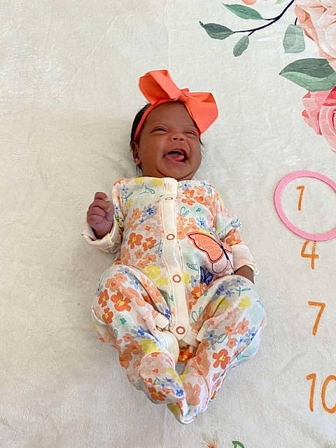 Sailor is registered to the contest to win money with this photo: baby, baby_toddler_clothing, cap, child, clothing, design, facial_expression, happy, linens, magenta, outerwear, pattern, peach, person, pink, skin, sleeve, smile, t_shirt, textile