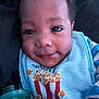 Aaron joined the competition — help win amazing prizes! baby, infant, face, eyes, smile, bib, popcorn, pacifier, drool, pajamas, striped_pajamas, close_up, portrait, arm, hair, clothing, dark_background, seat, accessory, soft_lighting