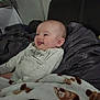 Aurora joined the competition — help win amazing prizes! baby, infant, tongue_out, blanket, monkey_print, bed, bedding, headboard, cozy, happy, smiling, clothing, onesie, person, indoor, cute, young_child, face, skin, resting