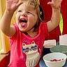 toddler, child, smiling, happy, pink_shirt, cat_graphic, shorts, indoor_playhouse, table, bowls, strawberries, raising_hands, cute, playful, blond_hair, casual_clothing, fun, joyful, portrait, daylight