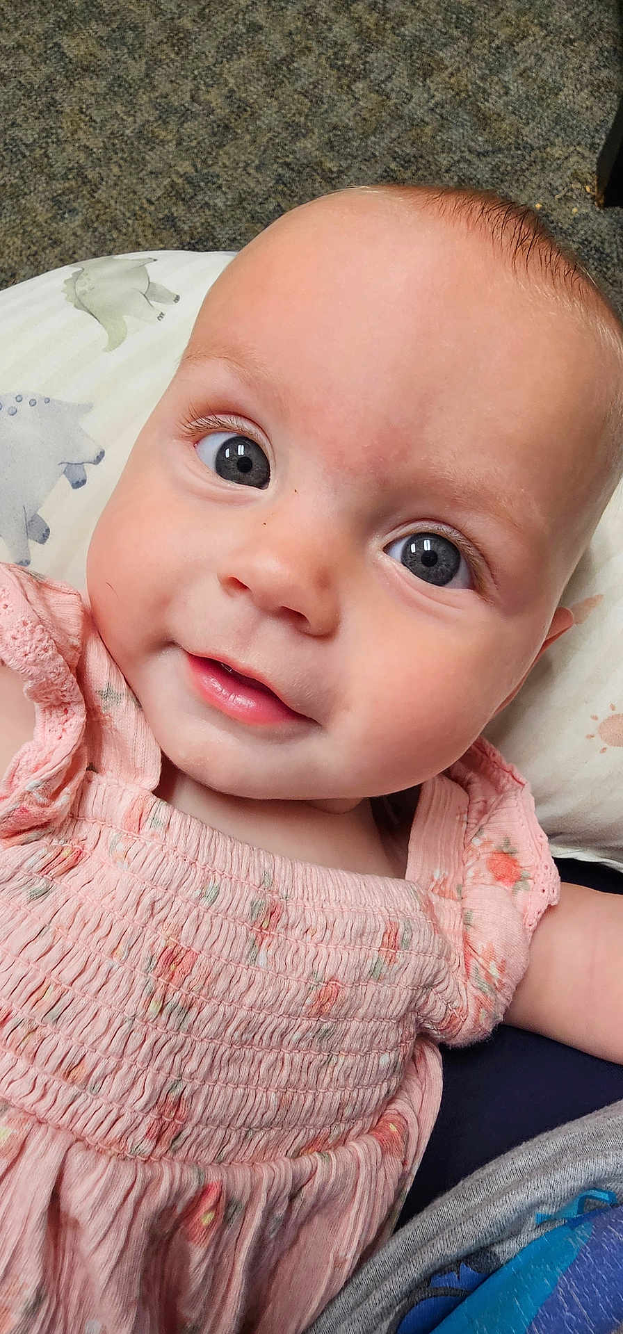 Stella joined the competition — help win amazing prizes! baby, infant, close_up, face, eyes, smile, pink_dress, patterned_clothing, cushion, carpet, child, cute, skin, person, portrait, young, indoors, head, expression, happy