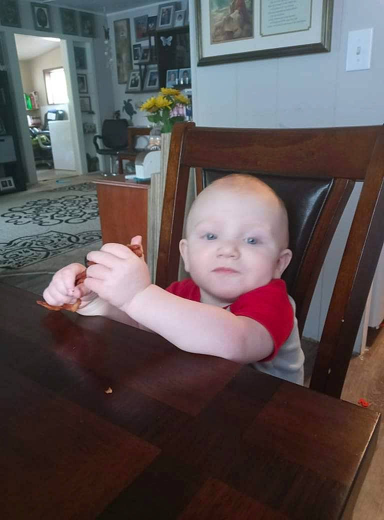 Rowan is registered to the contest to win money with this photo: baby, baby_toddler_clothing, chair, cheek, comfort, floor, flooring, furniture, hardwood, houseplant, interior_design, living_room, person, picture_frame, plant, room, table, toddler, varnish, wood