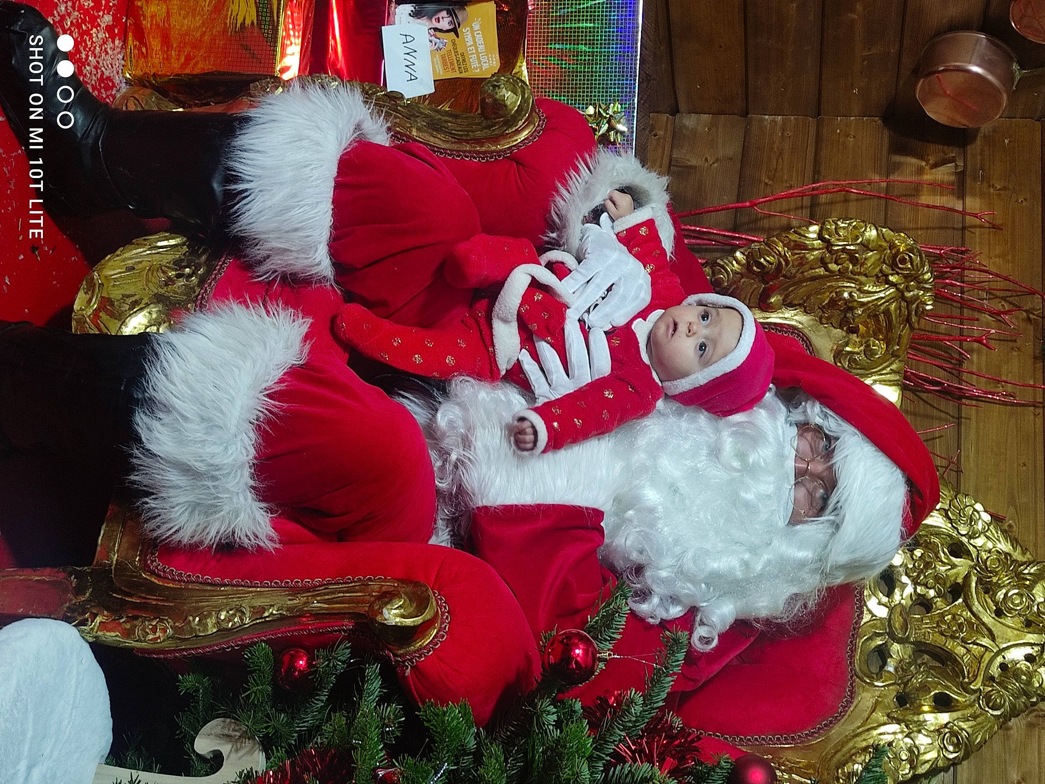 Julia participe au concours pour gagner de l'argent avec cette photo : carmine, christmas_decoration, christmas_eve, christmas_lights, christmas_ornament, christmas_tree, event, fictional_character, fur, fur_clothing, hat, headwear, holiday, holiday_ornament, lap, ornament, person, red, santa_claus, tradition