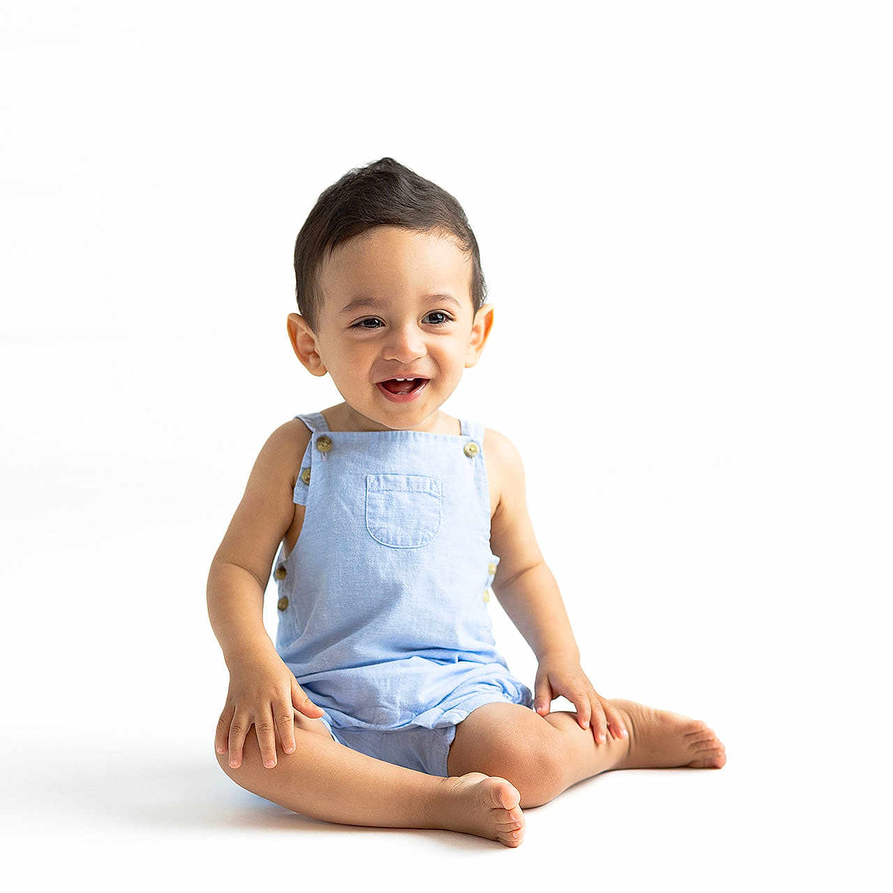 Nicolas joined the competition — help win amazing prizes! baby, barefoot, blue_overalls, casual_clothing, child, cute, happy, indoors, infant, isolated, one_person, playful, portrait, positive_emotion, sitting, smiling, studio, toddler, white_background, young_child