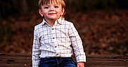 Ryker joined the competition — help win amazing prizes! child, toddler, smile, outdoor, autumn, picnic_table, jeans, shirt, brown_shoes, bench, leaves, nature, forest, portrait, cute, young_child, fall, casual_clothing, happy, daylight