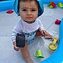 Abygaïl a rejoint le concours — aidez-le/la à gagner de superbes lots ! toddler, child, pool, inflatable_pool, water, toy, hat, blue_hat, plastic_toy, cup, scoop, outdoor, summer, play, sitting, young_child, serious_expression, clothing, backyard, fun