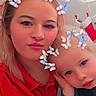 Arthur is registered to the contest to win money with this photo: woman, child, selfie, butterfly_filter, face, portrait, indoor, christmas_tree, holiday_decor, stockings, red_shirt, blond_hair, casual_clothing, window_blinds, family, cute, closeup, digital_filter, together, smiling