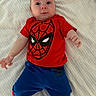 baby, child, infant, spiderman, red_shirt, blue_pants, clothing, lying_down, blanket, indoor, cute, portrait, face, hands, feet, expression, person, young, casual, comfortable