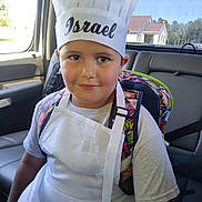 Israel joined the competition — help win amazing prizes! child, boy, young_chef, chef_hat, paper_hat, apron, backpack, car, car_interior, back_seat, portrait, smiling, face, eyes, outdoor_view, house, sunlight, casual_clothing, cooking, family_photo