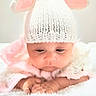 Princesa is registered to the contest to win money with this photo: baby, infant, child, portrait, sleepy, crocheted_hat, sheep_hat, pink, white, blanket, fluffy, textile, cozy, lying_down, hands, face, eyes, nursery, soft_lighting, indoor