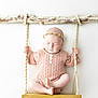 baby, infant, swing, wood, rope, headband, pink_clothing, closed_eyes, peaceful, cute, portrait, studio, knitwear, soft_lighting, minimalist, white_background, child, newborn, sitting, decorative