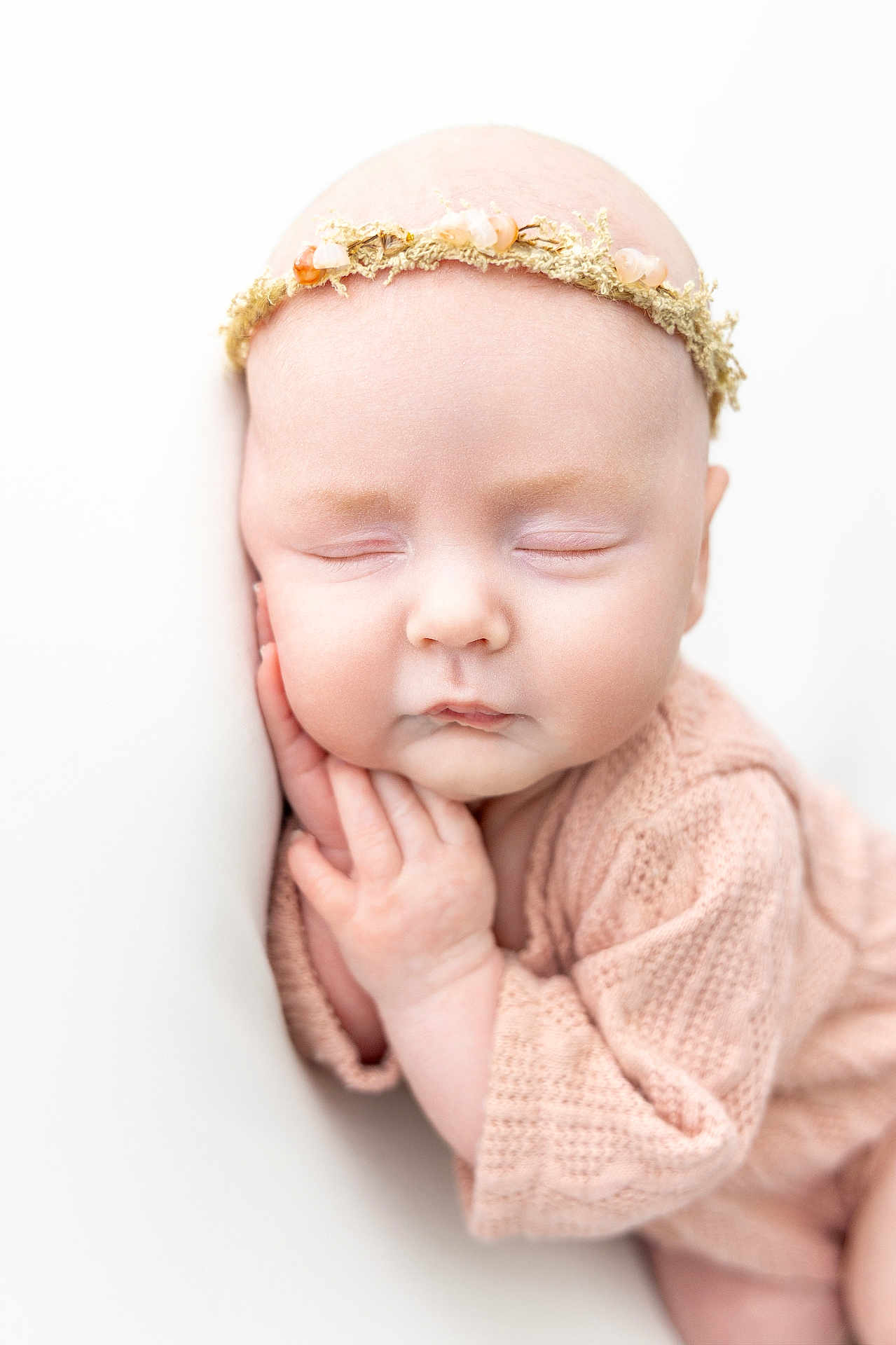 Lottie is registered to the contest to win money with this photo: baby, newborn, sleeping, headband, flower_crown, knitted_clothing, soft_light, close_up, peaceful, infant, cute, skin, hand, face, resting, portrait, cozy, gentle, white_background, serene