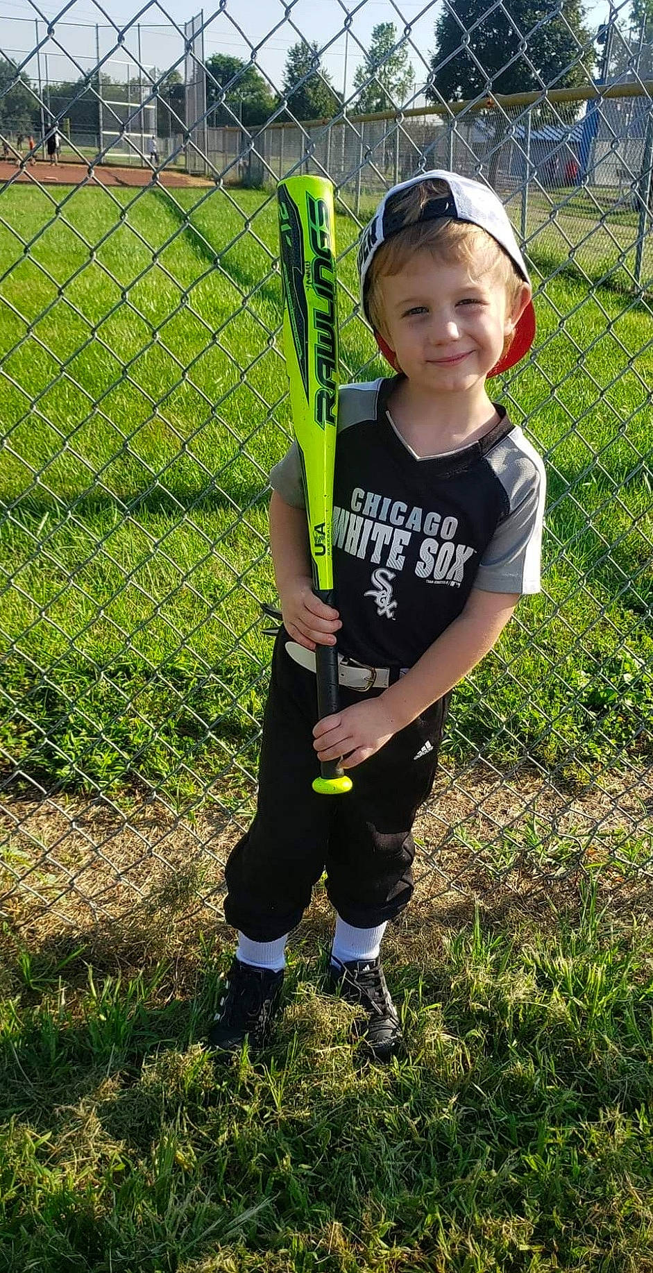 Kayden joined the competition — help win amazing prizes! chain_link_fencing, child, fence, grass, grass_family, hat, joy, lawn, mesh, net, people_in_nature, person, personal_protective_equipment, player, shorts, smile, sneakers, sports_equipment, t_shirt, team_sport
