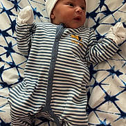 Keyronn a rejoint le concours — aidez-le/la à gagner de superbes lots ! baby, infant, onesie, hat, mittens, socks, blanket, pattern, striped_clothing, bed, lying_down, cute, face, small_hands, small_feet, indoor, soft, newborn, child, portrait