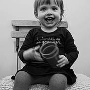 Loxane a rejoint le concours — aidez-le/la à gagner de superbes lots ! child, toddler, smiling, black_and_white, bench, wooden_bench, cup, toy, portrait, sitting, happy, clothing, dress, tights, chair, cushion, indoor, screenshot_ui, grin, playful