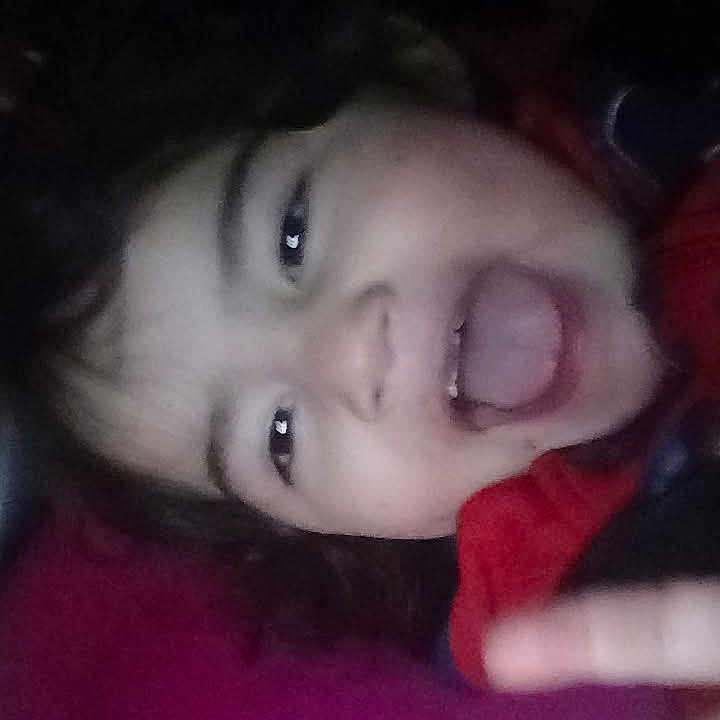 Davinia joined the competition — help win amazing prizes! blur, casual, child, close_up, dark_background, expression, face, hair, hand, happy, indoor, joyful, peace_sign, person, playful, portrait, red_clothing, smiling, tongue, young