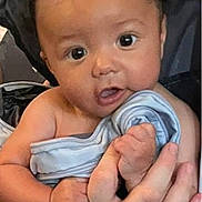Hayden is registered to the contest to win money with this photo: baby, infant, child, face, eyes, hand, blanket, clothing, person, skin, cute, newborn, expression, portrait, holding, soft, indoors, human, small, adorable