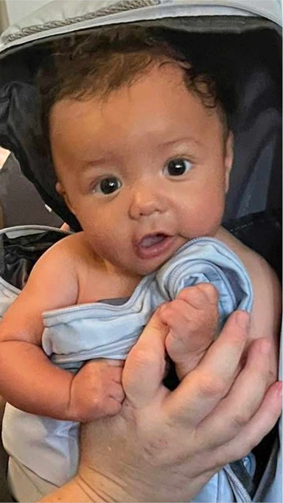 Hayden is registered to the contest to win money with this photo: baby, infant, child, face, eyes, hand, blanket, clothing, person, skin, cute, newborn, expression, portrait, holding, soft, indoors, human, small, adorable