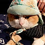 Roméo participe au concours pour gagner de l'argent avec cette photo : cat, pet, animal, hat, bonnet, clothing, striped, pattern, paw, fur, orange, white, cute, indoor, resting, closeup, face, whiskers, human_hand, fabric