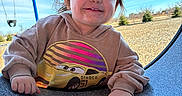 Tessa joined the competition — help win amazing prizes! toddler, child, hoodie, smiling, playground, outdoor, blue_sky, swing, sunlight, happy, face, hand, casual_clothing, daytime, nature, grass, trees, cute, portrait, playtime