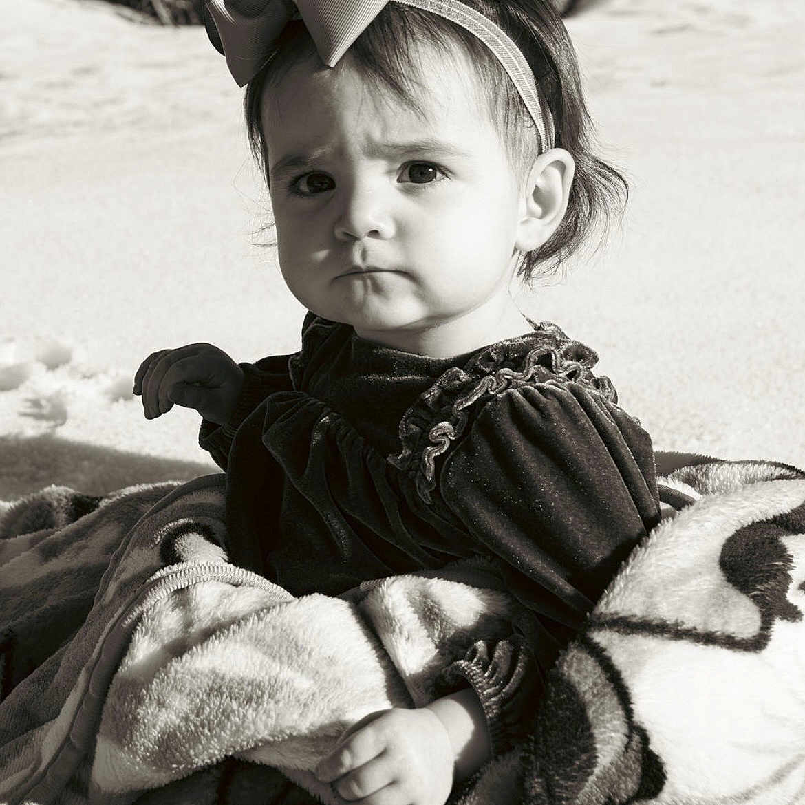 Tessa joined the competition — help win amazing prizes! toddler, child, face, blanket, bow, headband, outdoor, portrait, expression, curious, clothing, monochrome, black_and_white, sitting, soft_texture, young_child, cute, baby_shoes, nature, photography