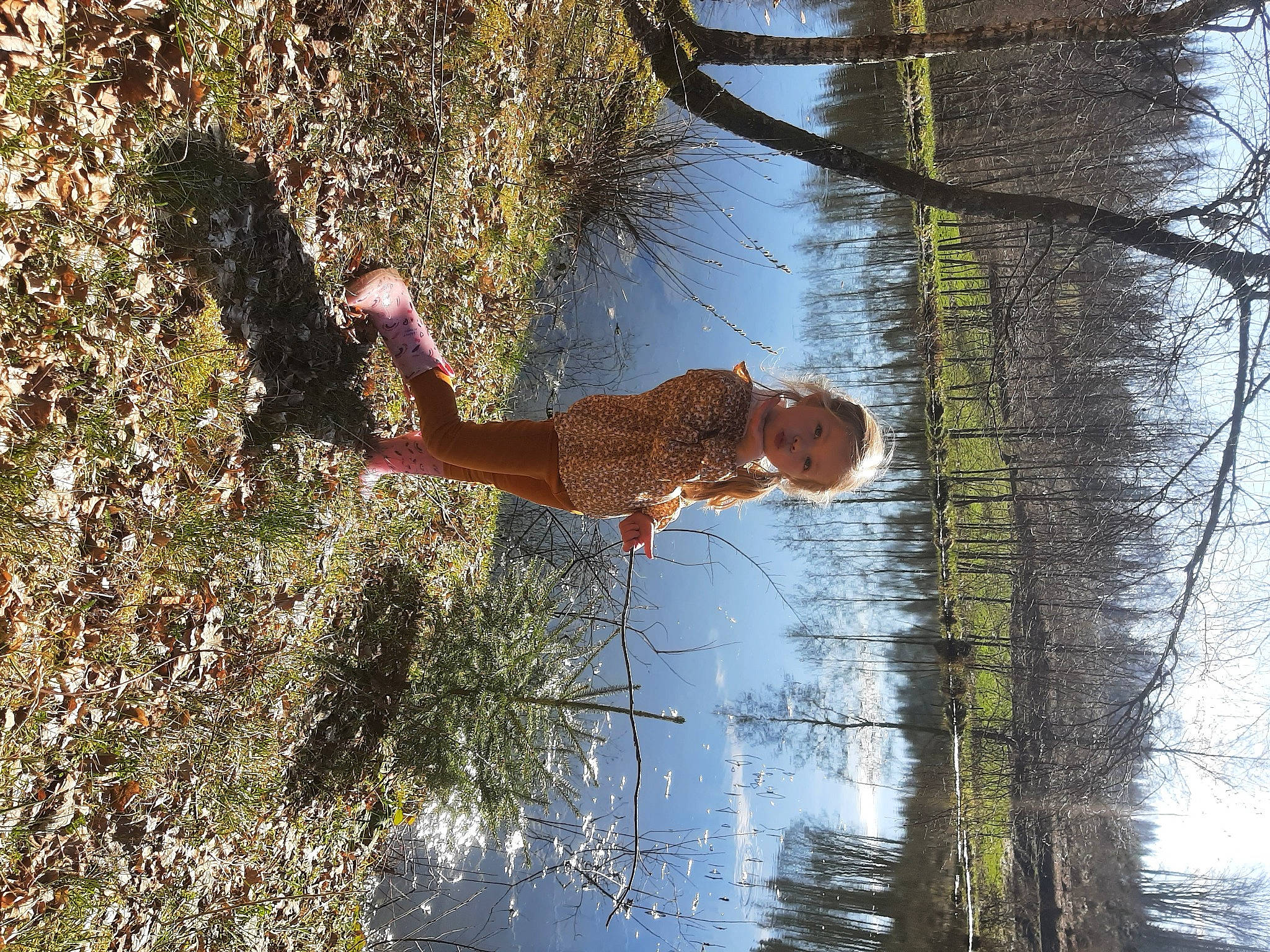 Elina participe au concours pour gagner de l'argent avec cette photo : bank, biome, branch, fun, grass, grass_family, happy, lake, leisure, natural_landscape, people_in_nature, person, plant, recreation, sky, tree, trunk, twig, water, wood