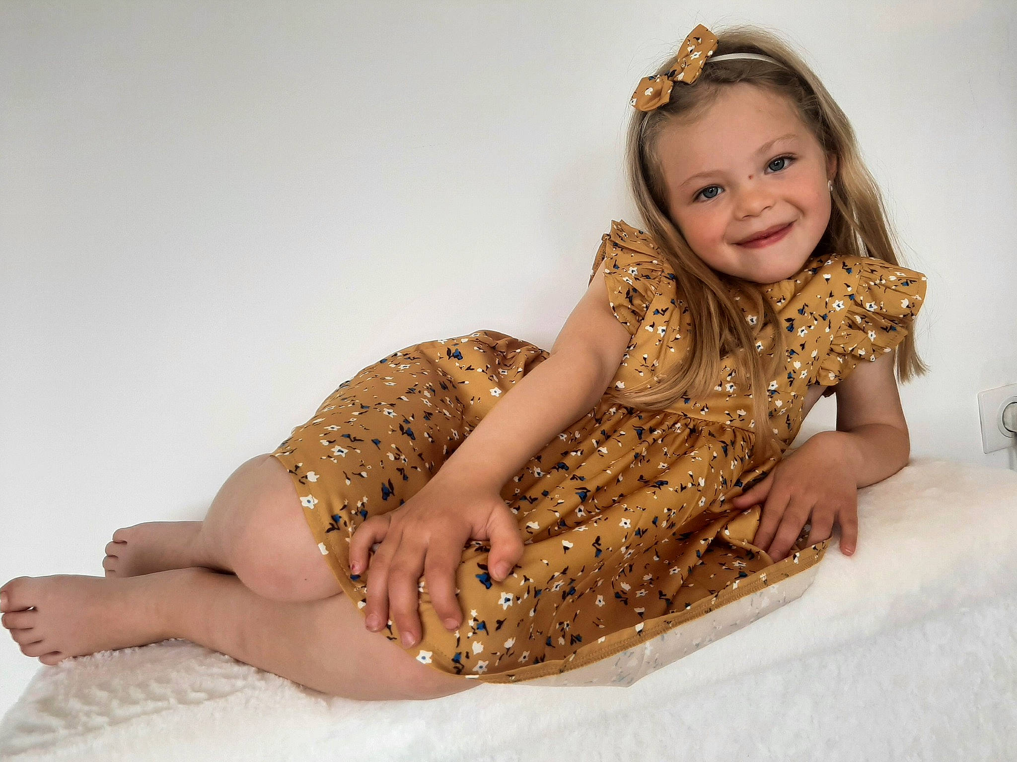 Elina participe au concours pour gagner de l'argent avec cette photo : baby_toddler_clothing, barefoot, child, comfort, fashion_design, flooring, hair, happy, head, human_body, human_leg, joy, knee, long_hair, pattern, person, skin, sleeve, smile, thigh