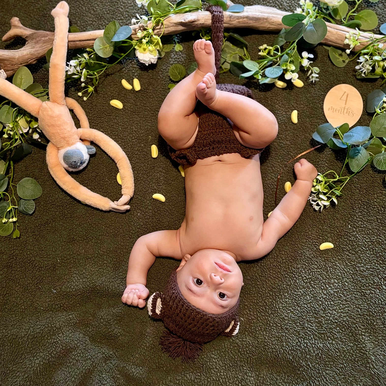 Léliano a rejoint le concours — aidez-le/la à gagner de superbes lots ! baby, child, chubby, cute, decorative_leaves, face, four_months, green_blanket, hand, indoors, infant, knitted_hat, laying_down, legs, playful, plush_toy, smiling, soft_texture, white_flowers, wooden_sign