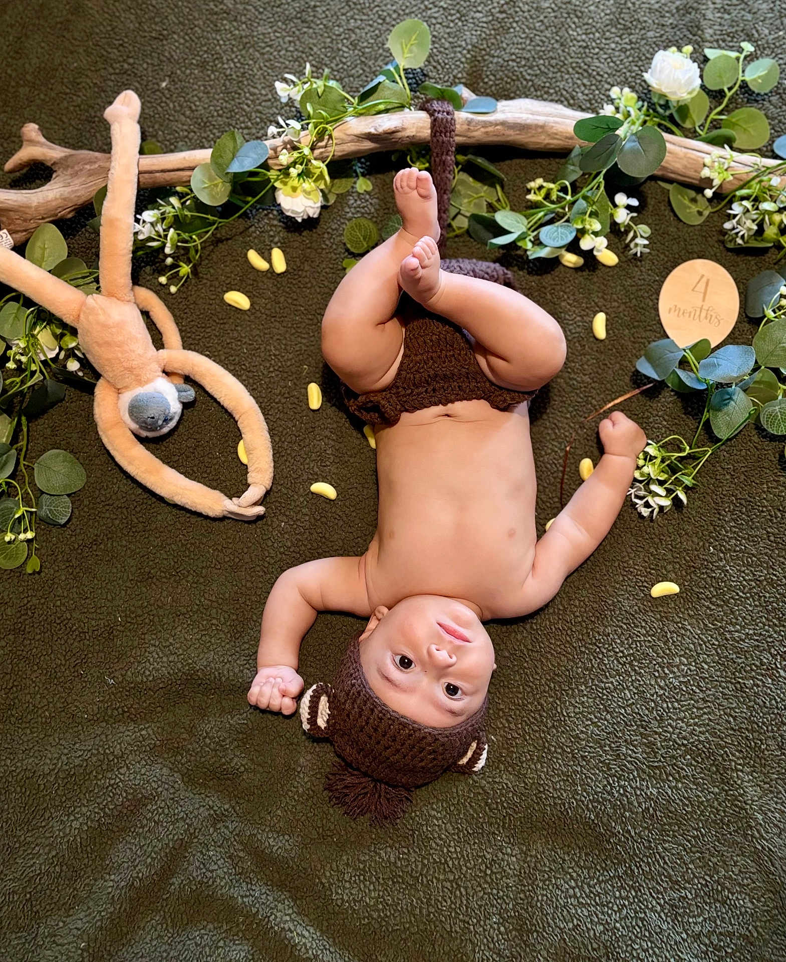 Léliano a rejoint le concours — aidez-le/la à gagner de superbes lots ! baby, child, chubby, cute, decorative_leaves, face, four_months, green_blanket, hand, indoors, infant, knitted_hat, laying_down, legs, playful, plush_toy, smiling, soft_texture, white_flowers, wooden_sign