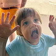 Karol a rejoint le concours — aidez-le/la à gagner de superbes lots ! adult, casual, child, closeup, curiosity, daylight, expression, face, fun, glass, hands, outdoor, person, playful, portrait, shirtless, shorts, toddler, tongue, window