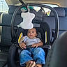 baby, car_seat, car_interior, child, infant, plush_toy, seatbelt, casual_clothing, jeans, sandal, striped_shirt, window, sunlight, headrest, seat, safety, child_seat, toy, looking_up, indoors