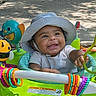 baby, child, hat, walker, toy, outdoor, smiling, happy, play, colorful, ring, plastic, seat, sunhat, curious, infant, person, face, daylight, shadow