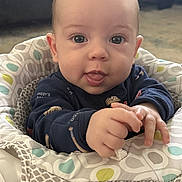 Julian joined the competition — help win amazing prizes! baby, child, infant, portrait, sitting, bouncer, baby_seat, patterned_fabric, navy_clothing, tongue, wide_eyes, hands, indoor, home, close_up, face, smiling, curious, soft_lighting, photography