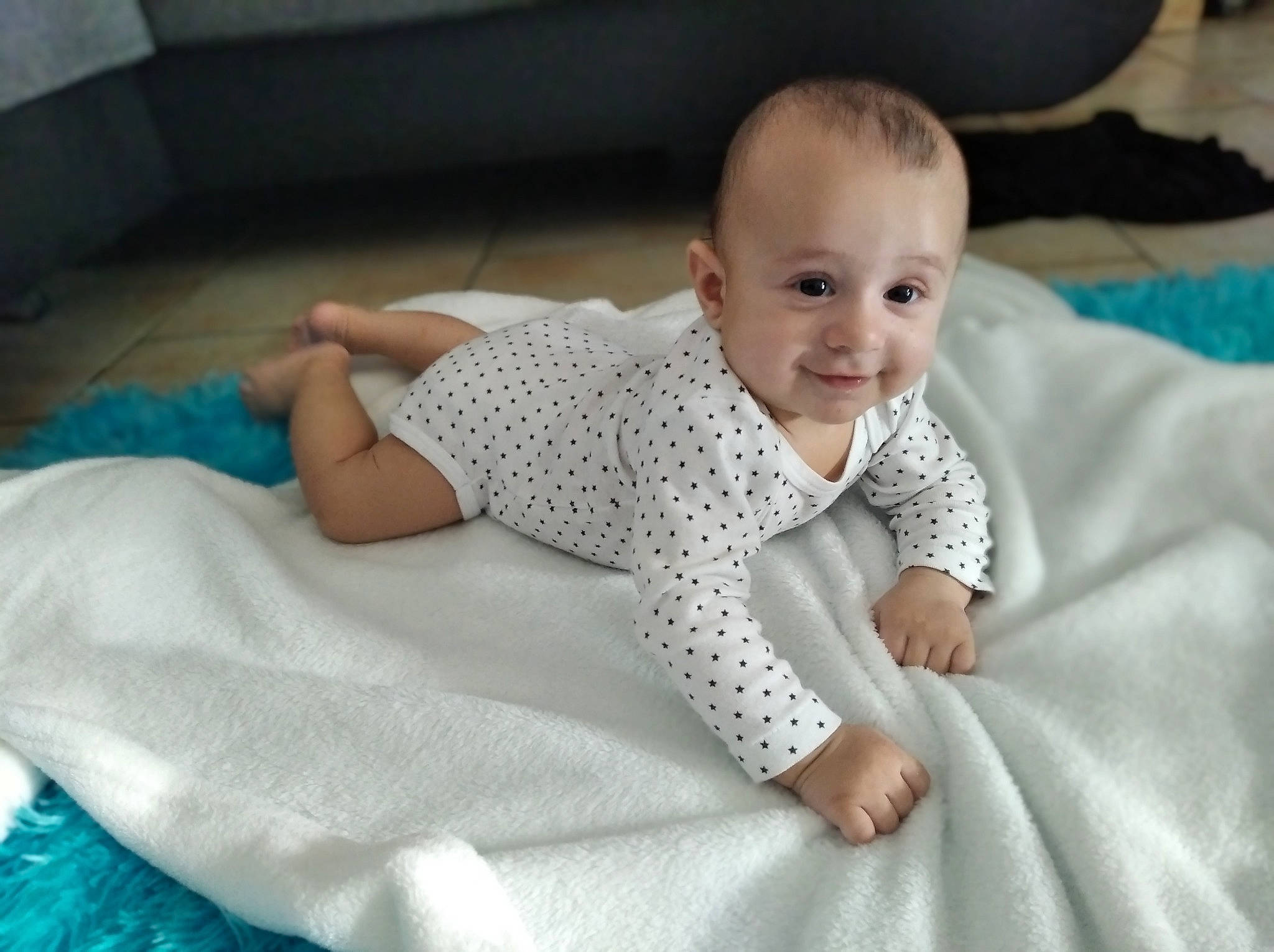 Tayden a rejoint le concours — aidez-le/la à gagner de superbes lots ! baby, baby_toddler_clothing, child, chin, comfort, facial_expression, flooring, fun, happy, iris, joy, linens, pattern, person, portrait_photography, room, sitting, skin, sleeve, smile