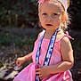 accessory, blonde_hair, child, curious_expression, cute, daylight, fashion, flower, girl, headband, lanyard, nature, outdoor, pink_dress, portrait, sitting, stitch, summer, sunlight, young_child