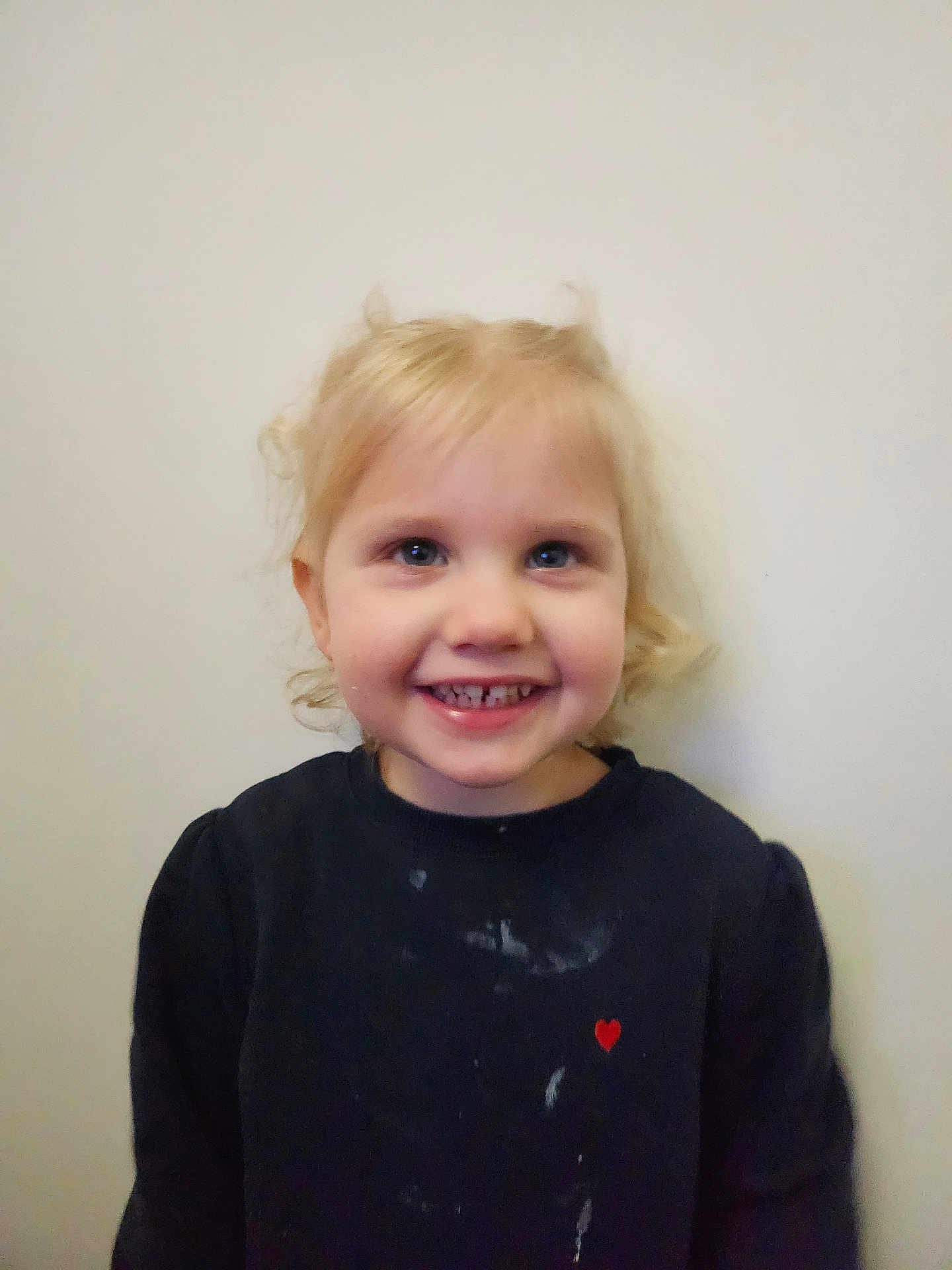 Séréna a rejoint le concours — aidez-le/la à gagner de superbes lots ! child, toddler, smile, blond_hair, portrait, face, eyes, teeth, sweater, red_heart, stains, indoor, plain_wall, hair, cheeks, cute, happy, looking_at_camera, person, head