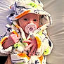 Everleigh joined the competition — help win amazing prizes! baby, infant, pacifier, hooded_robe, fluffy_clothing, hand, face, wide_eyes, cute, child, newborn, soft_texture, colorful, white_background, portrait, expression, cozy, sleepwear, person, lying_down