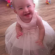 Addison joined the competition — help win amazing prizes! toddler, child, dress, white_dress, pearl_embellishments, smiling, happy, indoor, wooden_floor, toys, colorful_toys, baby, person, cute, motion_blur, floor, playtime, girl, infant, celebration