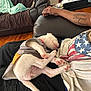 White Girl is registered to the contest to win money with this photo: arm, blanket, casual, comfort, couch, cozy, cute, dog, fur, home, indoors, living_room, person, pet, puppy, relaxing, resting, shirt, sleeping, tattoo