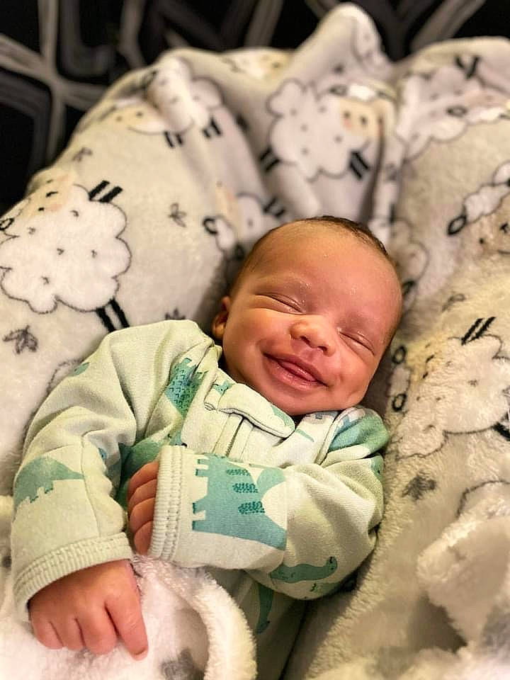 Jakari joined the competition — help win amazing prizes! baby, baby_sleeping, baby_toddler_clothing, bedding, bedtime, cheek, child, comfort, grass, happy, linens, pattern, person, photograph, room, sitting, skin, sleeve, smile, textile